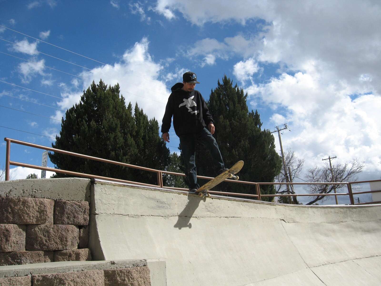 Rollerblader grinding on rail in skate park outdoors.Trick is