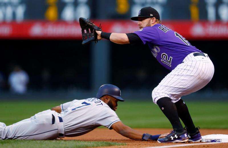 Retired Colorado Rockies first baseman Todd Helton, left, jokes