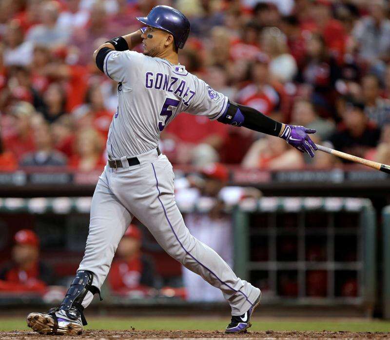 Colorado Rockies' Carlos Gonzalez takes a practice swing as he