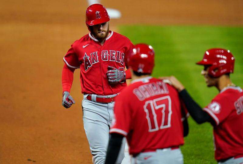 Los Angeles Angels pitcher Jaime Barria, right, sits in the dugout